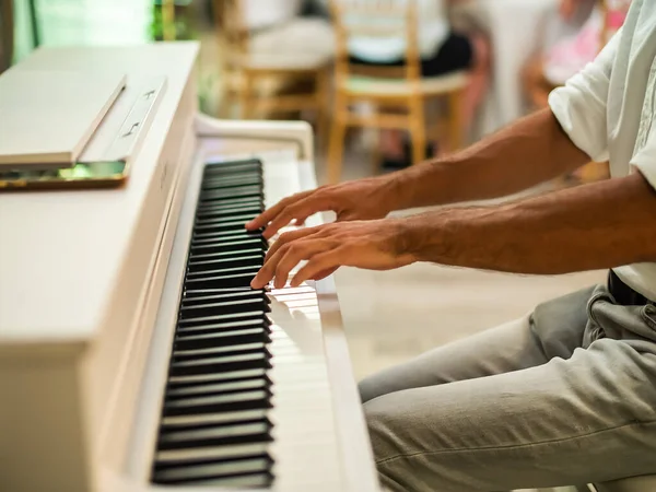 Male pianist hands on grand piano keyboard - music event and artist musician