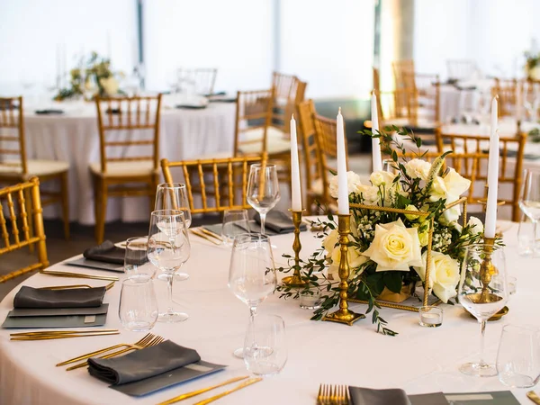 stock image Table at a luxury wedding reception. Beautiful flowers on the table. Serving dishes, glass glasses, waiters work,