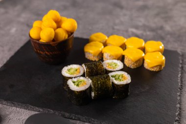 Karanlık arka planda suşi yuvarlanıyor. Japon ve Asya yemekleri