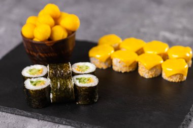 Karanlık arka planda suşi yuvarlanıyor. Japon ve Asya yemekleri
