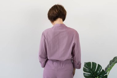 Güzel renkli pijama giymiş, oturma odasında model kılığına girmiş çekici bir kadın. Rahat uyku giysileri, ev rahatlığı ve kadın moda konsepti.