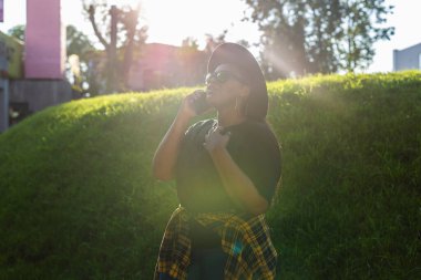 Şehirde cep telefonuyla konuşan mutlu Afrikalı Amerikalı genç bir kadının yakın plan portresi.