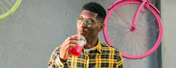 stock image Young cheerful african american male on city having fun and holding cocktail. Man on summer holiday. Leisure lifestyle holiday and summer drinks concept.
