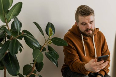 Cep telefonu kullanan serbest çalışan, sosyal medya ağını kontrol eden ya da evdeki yatakta oturup mesajlaşan biri. Sıkı çalışma gününden sonra çevrimiçi dijital iletişim dinlenme