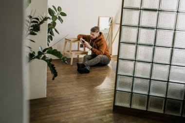 Cep telefonu kullanan serbest çalışan, sosyal medya ağını kontrol eden ya da evdeki yatakta oturup mesajlaşan biri. Sıkı çalışma gününden sonra çevrimiçi dijital iletişim dinlenme