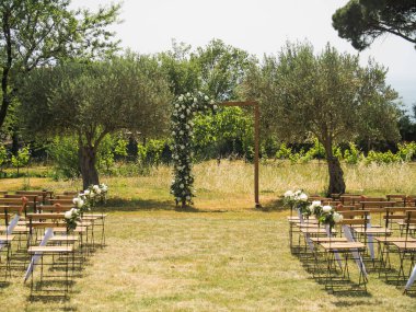 Düğün kemeri ve dışarıda misafirler için sandalyeler.