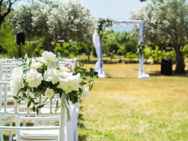 Düğün kemeri ve dışarıda misafirler için sandalyeler.