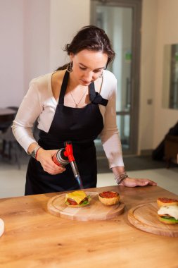 Lezzetli hamburgerler hazırlıyorum. Şef biftek, peynir ve sebzeli köfte pişiriyor.