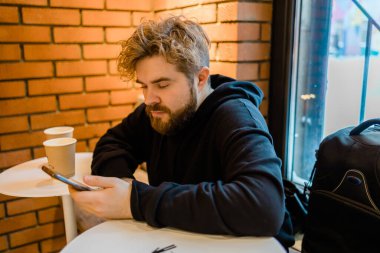 Yakışıklı, konsantre bir adam cep telefonuyla para transferi yapıyor. Sokak akşamları internet kafede oturuyor. Ciddi bir milenyum adamı akıllı telefondan mesaj okuyor.