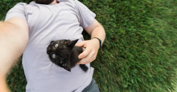 男人带着小猫躺在草地上玩耍 友谊爱动物和宠物的主人 — 图库照片
