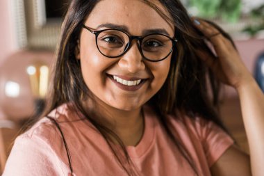 Head shot portrait smart confident smiling millennial indian woman. Attractive young hindu teenager student girl freelancer looking at camera, posing for photo