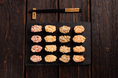 Set of Gunkan Maki Sushi with different types of fish salmon, scallop, perch, eel, shrimp and caviar on wooden table background. Sushi menu. Japanese food sushi set gunkan