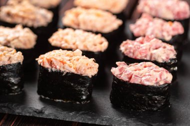 Set of Gunkan Maki Sushi with different types of fish salmon, scallop, perch, eel, shrimp and caviar on wooden table background. Sushi menu. Japanese food sushi set gunkan