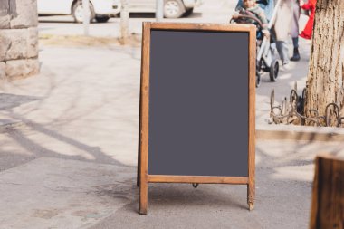 Restoran girişinin önündeki tahta tahta. Dükkan ya da kafe restoranının yanındaki boş pano standını düzenle. Sokak kaldırım tahtası.