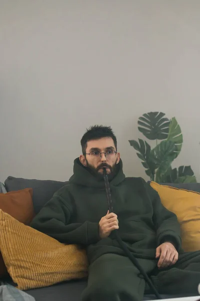 Bearded Millennial Gen Man Smoking Hookah While Relaxing Sofa Home — Foto de Stock
