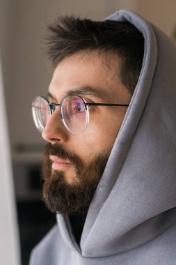 Hüzünlü bir günde özlem duyan ve pencereden dışarı bakan bir adam. Depresyon ve melankolik.