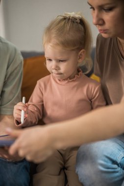 Deaf child girl with cochlear implant studying to hear sounds - recovery after cochlear Implant surgery and rehabilitation