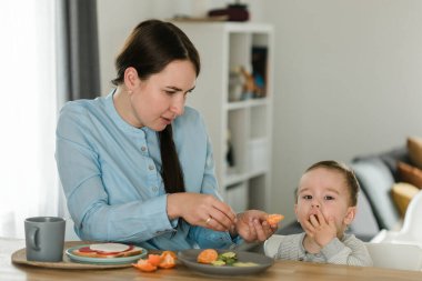 Genç anne bebek oğlu meyve püresi ile besleme