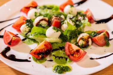 Plate of Healthy Classic Caprese Salad with Mozzarella Cheese, Tomatoes and Basil