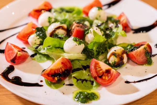 Plate of Healthy Classic Caprese Salad with Mozzarella Cheese, Tomatoes and Basil