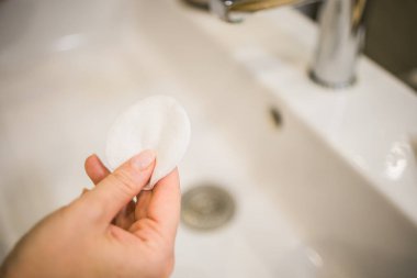 Pamuk pedi tutan bir kadın. Güzellik, kaplıca, vücut bakımı. Makyaj temizleme kavramı