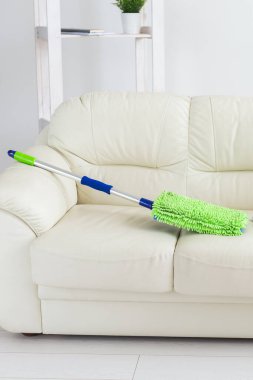 Yeni temiz yeşil mikrofiber paspas yer silecek temizleme aracı kanepede yatıyor.