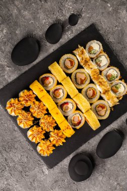 Karanlık arka planda suşi yuvarlanıyor. Japon ve Asya yemekleri