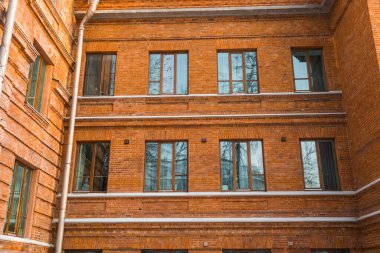 Kırmızı tuğlalı eski bir binanın afiş pencereleri