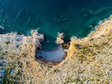 Güzel bir deniz limanının manzarası. Turkuaz suyu olan bir göl. Kayalık kıyılara yakın dalgalar
