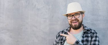 guy tourist looking happy wearing straw hat for travelling, standing against concrete wall background with copy space