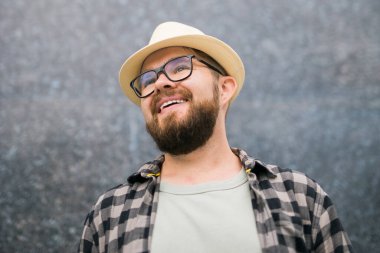 guy tourist looking happy wearing straw hat for travelling, standing against concrete wall background with copy space