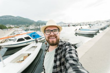Gezgin milenyum adamı güneşli bir günde lüks yat selfie 'si çekiyor. Seyahat ve yaz.