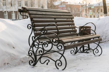 Şehirde ya da kasabada karla kaplı parktaki sokak bankı. Metin ve reklam için boşluk ve boşluğu kopyala.