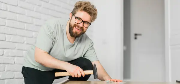 Young attractive man assembles furniture - handwerker and interior objects