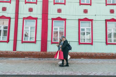 Mutlu arkadaşlar alışveriş yapıyor. Alışveriş torbalarıyla alışveriş yapan iki güzel genç kadın. Tüketim ve arkadaşlık kavramı.