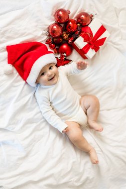 Güzel küçük bebek Noel kutluyor. Yeni yıl tatilleri. Bebek Kostüm giymiş bir Noel hediye ile.