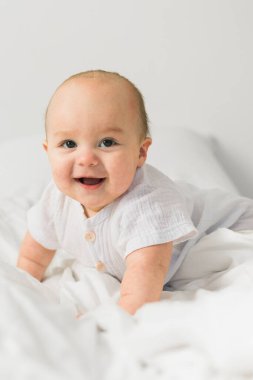 Mutlu bebek yatakta yatıp gülüyor. Alfa ve alfa jenerasyonu..