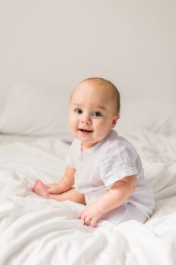 Mutlu bebek yatakta yatıp gülüyor. Alfa ve alfa jenerasyonu..