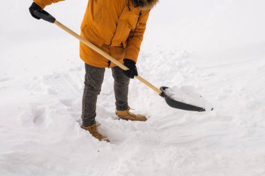 Adam evin yakınındaki karları temizliyor ve merdivenlerde kış mevsiminde topallıyor. Kış fırtınası ve mevsime özel.