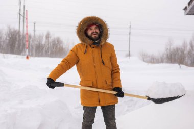 Adam evin yakınındaki karları temizliyor ve merdivenlerde kış mevsiminde topallıyor. Kış fırtınası ve mevsime özel.