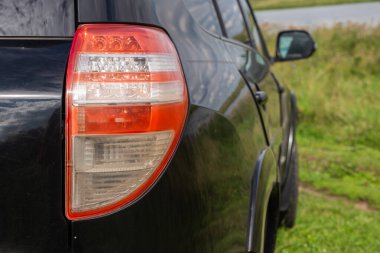 Yeni siyah araba arkadan görünüm. Closeup farlar bir araba. Siyah sigorta primi şehir crossover, lüks Suv arka ışık portre. Araba lamba yakın çekim.