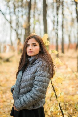 Sonbaharda, kendine güveni tam, genç bir Hintli kadının açık havada çekilmiş portresi. Mutlu ve doğal gülümseyen bir kadın. Z ve Z jenerasyonu gençliği