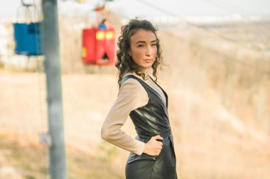 Sonbahar ormanındaki kız. Uzun kıvırcık saçlı kadın. Ormanda güzel bir güneş ışığı var. Saç bakımı. Milenyum Jenerasyonu ve gençliği