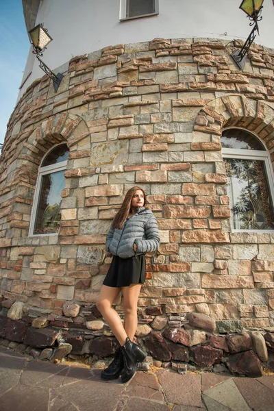 Portrait of diversity young beautiful confident Indian Asian woman in fall season brick building background. Happy and natural smiling female. Generation z and gen z youth