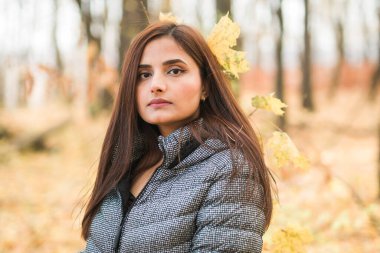 Açık havada güneşli bir sonbahar tatili yapan güzel Hintli genç bir kadının portresi. Z jenerasyonu ve Z jenerasyonu kavramı. Sonbahar Sezonu.