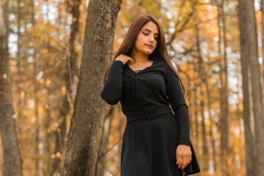 Açık havada güneşli bir sonbahar tatili yapan güzel Hintli genç bir kadının portresi. Z jenerasyonu ve Z jenerasyonu kavramı. Sonbahar Sezonu.