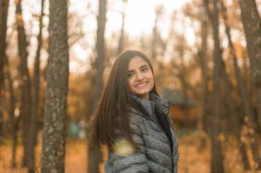 Açık havada güneşli bir sonbahar tatili yapan güzel Hintli genç bir kadının portresi. Z jenerasyonu ve Z jenerasyonu kavramı. Sonbahar Sezonu.