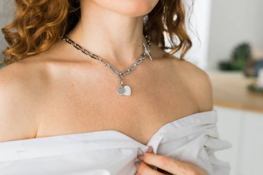 Gümüş kolyeli bir kadın, yakın plan. E-ticaret, çevrimiçi satış, sosyal medya, mücevher satışı. El yapımı mücevherler..