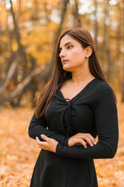 Açık havada güneşli bir sonbahar tatili yapan güzel Hintli genç bir kadının portresi. Z jenerasyonu ve Z jenerasyonu kavramı. Sonbahar Sezonu.