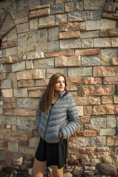 Portrait of diversity young beautiful confident Indian Asian woman in fall season brick building background. Happy and natural smiling female. Generation z and gen z youth